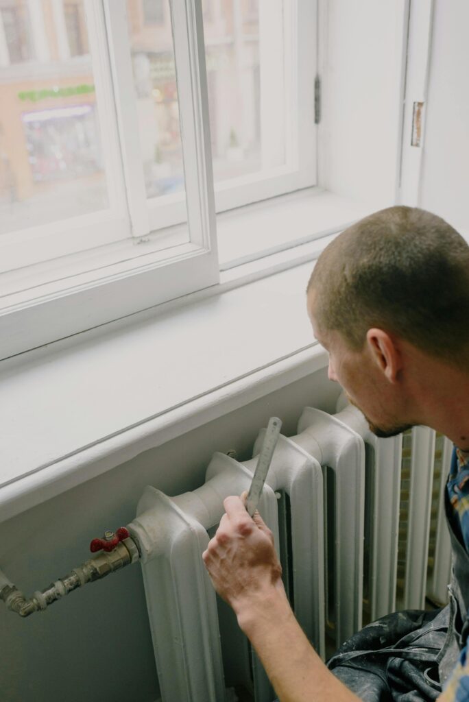 Plombier chauffagiste en train de réparer un radiateur